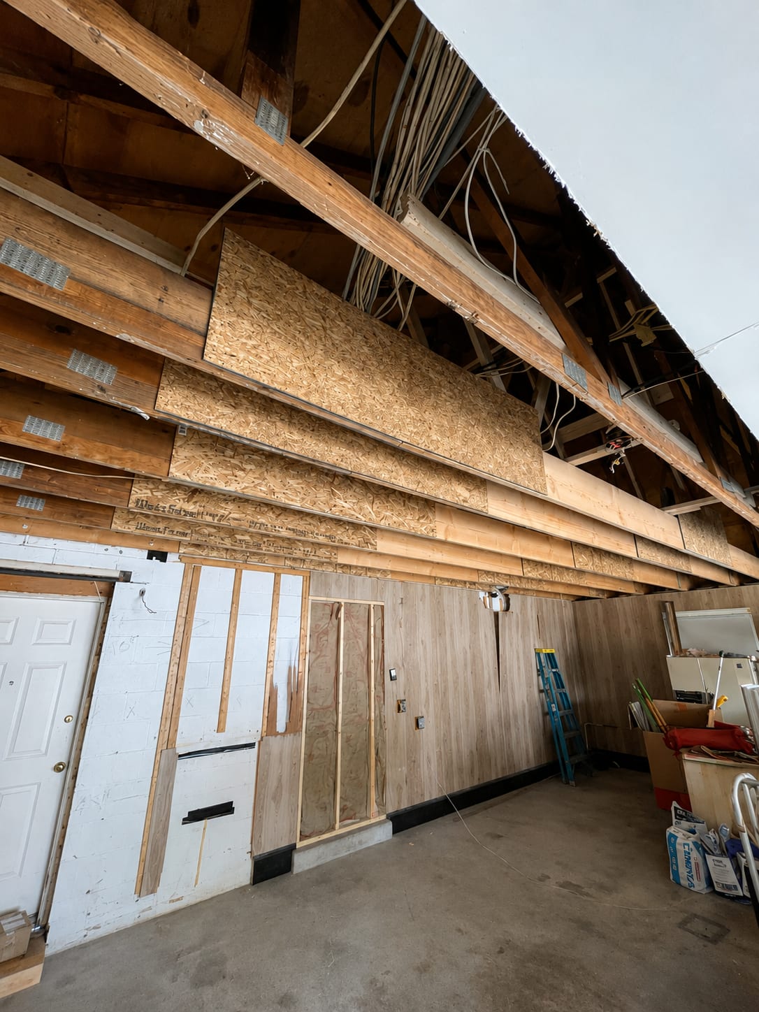 A garage ceiling opened up, the framing exposed and old boards hanging down, Great Falls, VA