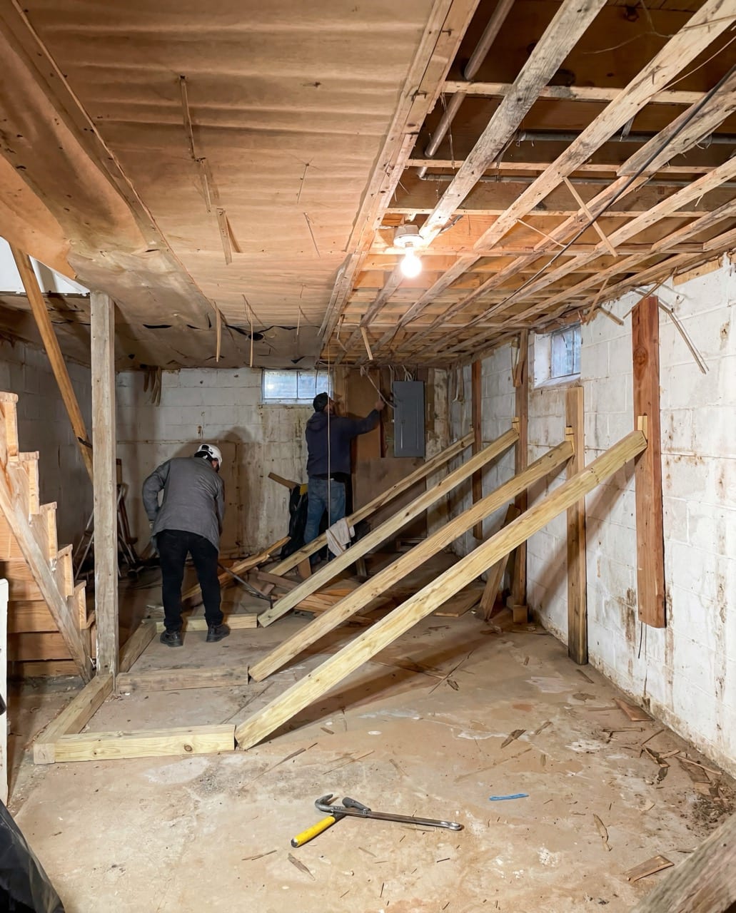Two crew members working at the braced basement wall, Frederick, MD